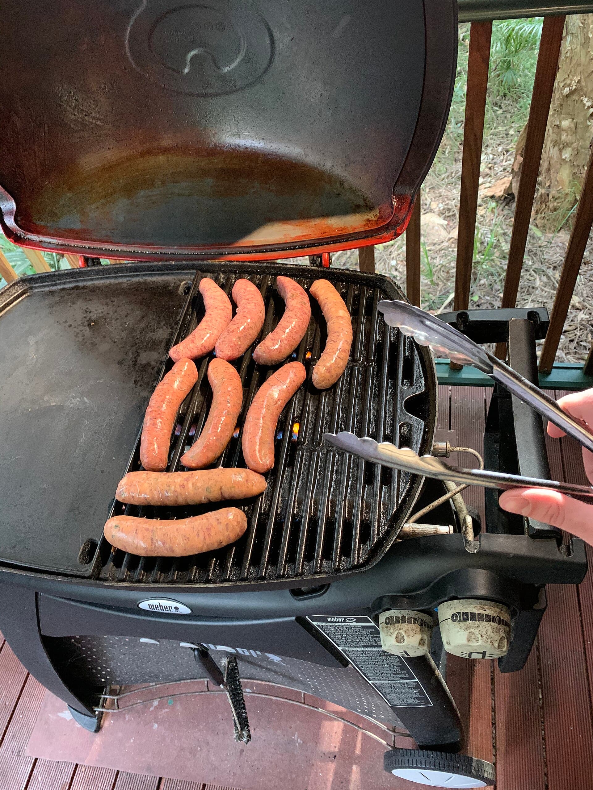 Sausages cooking in rows on a barbecue grate